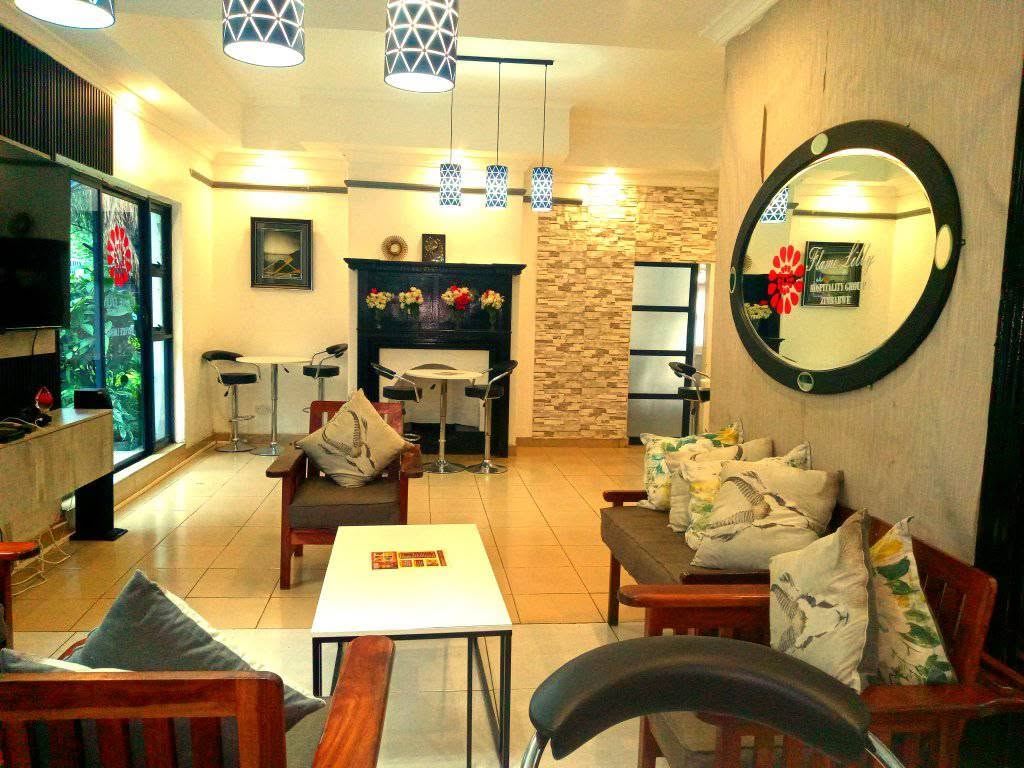 Another corner of the Bulawayo lounge with a round mirror and cushioned wooden seating