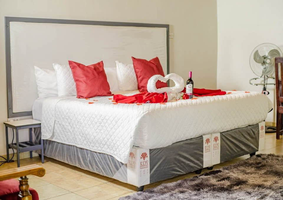 Wide view of a Harare bedroom with red cushions and a grey headboard