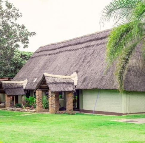 The thatched building and lawn at the Harare lodge